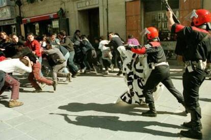 Agentes de la Ertzaintza se enfrentan a manifestantes convocados por Jarrai en Vitoria.