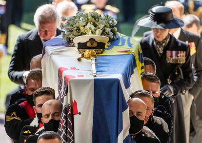 O caixão de Philip de Edimburgo coberto com seu estandarte, que evoca suas raízes gregas e dinamarquesas. Em cima, seu emblema naval e um ramo de flores brancas eleitas pela Rainha para honrar seu tempo juntos. Entre outras flores, a monarca selecionou lírios, que representam o renascimento, e as rosas, que simbolizam respeito e florescem em junho, mês em que Philip nasceu.