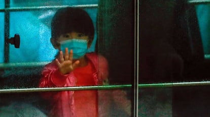 Una niña en un vehículo que transporta a los residentes evacuados de un edificio de viviendas públicas de las afueras de Hong Kong, el pasado 11 de febrero.