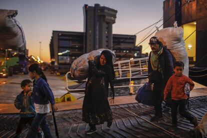 Refugiados y migrantes desembarcan de un ferry en el puerto de Pireo, cerca de Atenas, desde la isla de Lesbos.