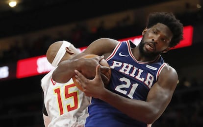 Joel Embiid agarra el balón ante Vince Carter.