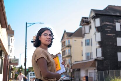 Lucía Mateo Pérez posa frente a su antiguo edificio de apartamentos en New Bedford, Massachusetts, en septiembre de 2021. Pérez fue una de las sobrevivientes del incendio que destruyó dos edificios en New Bedford el 19 de abril de este año.