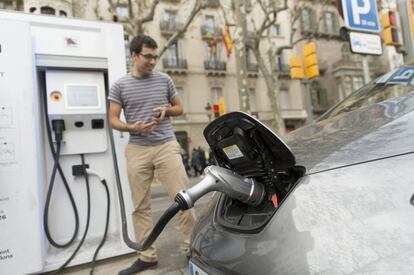 Un conductor recarga su coche eléctrico.