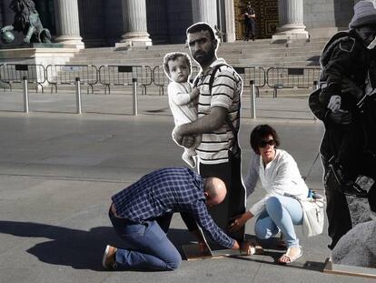 Miembros de Amnist&iacute;a Internacional colocan frente al Congreso varias im&aacute;genes de refugiados, este martes.