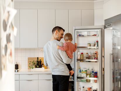 Un hombre con su hija en la cocina.
