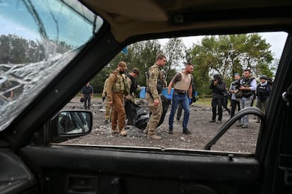 Un grupo de agentes de policía trasladan el cuerpo de una persona asesinada por el ataque ruso.