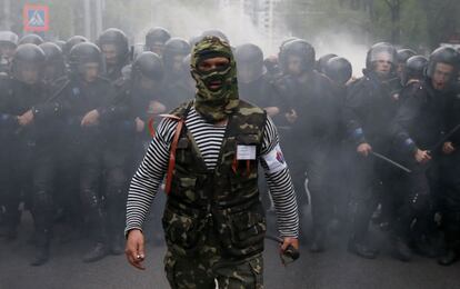 Un activista prorruso enmascarado comanda un compacto grupo de antidisturbios ucranio durante la celebración de un mitin proucranio en la ciudad de Donetsk el 28 de abril de 2014.