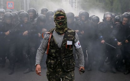 Un activista prorruso enmascarado comanda un compacto grupo de antidisturbios ucranio durante la celebración de un mitin proucranio en la ciudad de Donetsk el 28 de abril de 2014.