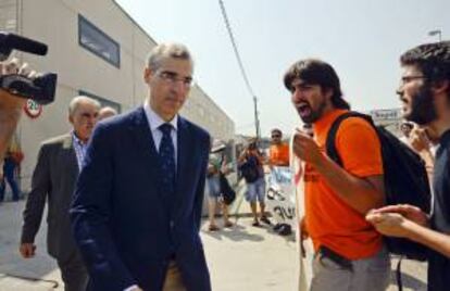 El conselleiro de Economía e Industria de la Xunta de Galicia, Francisco Conde (i), hoy durante una visita realizada a la empresa Rodríguez López Autos, en el Polígono de San Cibrao, Orense, donde ha informado, entre protestas de los trabajadores, de la apertura de un expediente de devolución de las ayudas al Grupo Isolux al que pertenece T-Solar, por incumplir sus objetivos, relativos a mantener su actividad y puestos de trabajo en la empresa.