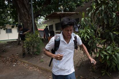 Un joven es afectado por los gases lacrimógenos lanzados por la policía en la Universidad Nacional Agraria en Managua.