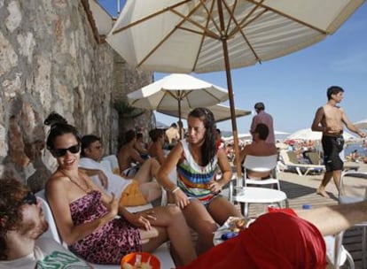 Gente tomando el sol en la playa de la Barra en Sitges.