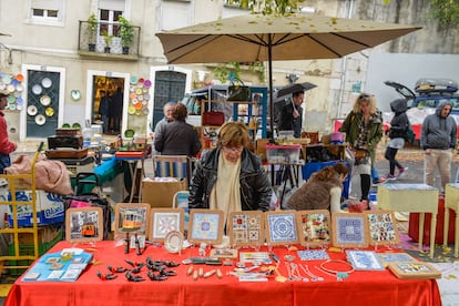 Una mujer con un puesto de azulejos en la Feria Popular da Ladra, en Lisboa.