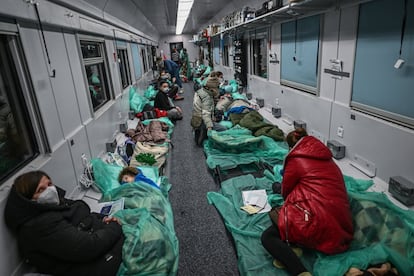 Madres se sientan junto a sus hijos en un vagón de tren transformado para transporte médico en Przemysl, Polonia. El canciller alemán, Olaf Scholz, ha hablado este viernes por teléfono con el presidente ruso, Vladímir Putin, y ha pedido a Moscú que detenga todas las acciones militares de inmediato, según ha anunciado un portavoz del Gobierno alemán. Scholz también ha reclamado a Putin que permita el acceso de ayuda humanitaria en las áreas donde se están produciendo combates.