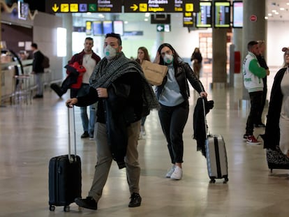 Viajeros procedentes de Italia protegidos con mascarillas a su llegada al aeropuerto de Manises (Valencia).