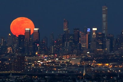 La Luna llena de color rojo sangre durante el eclipse más corto del siglo, se eleva sobre el horizonte de la ciudad de Nueva York, vista desde West Orange, Nueva Jersey.
