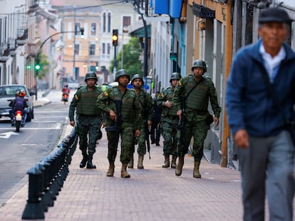 Soldados patrullan las calles de Quito mientras ciudadanos transitan, el 9 de enero.