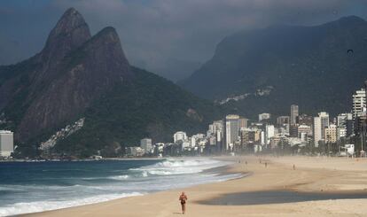 Un hombre hace ejercicio en la playa de Ipanema en Río de Janeiro, este sábado. Algunos de los accesos a Copacabana e Ipanema, dos de las más populares, en la zona sur de la capital fluminense, estaban bloqueados con cintas para indicar la prohibición de paso.