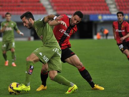 Dos jugadores luchan por el balón durante el Mallorca-Sporting