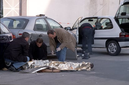 Los investigadores de homicidios examinan el cuerpo de una víctima de asesinato por sicarios, en el distrito de San Blas en 2002.