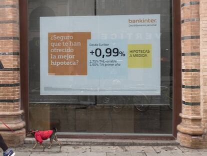 Una mujer pasa antes un anuncio hipotecario en Sevilla, en una imagen de archivo.