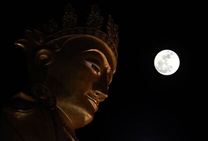 La superluna vista cerca de una estatua gigante de Buda en Yangon (Myanmar), el 3 de diciembre de 2017.
