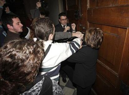 Varios estudiantes tratan de salir de un área tras bloquear el acceso a la reunión de rectores.