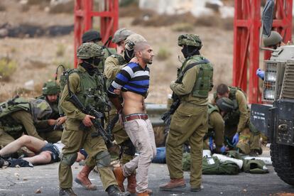 Soldados israelíes detienen a un palestino en el puesto militar de Beit El, cerca de Ramala (Cisjordania).