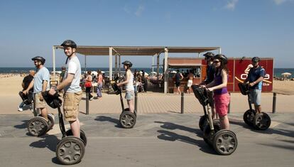 Un grupo de turistas pasea cerca de la playa de Barcelona.