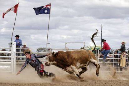 Un jinete es perseguido por un toro durante el rodeo de Deni en Deniliquin, Australia.