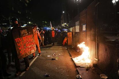 Aunque las manifestaciones empezaron de forma pacífica, terminaron con gas lacrimógeno después de que los manifestantes ataran cuerdas a las barricadas que rodeaban el Tribunal de Justicia de la ciudad para tratar de derribarlas. En la imagen, los manifestantes rodean el Tribunal de Justicia de Portland.