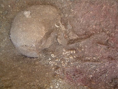 A detail of one of the burials with some indications of prestige: ochre and a limestone bead necklace.