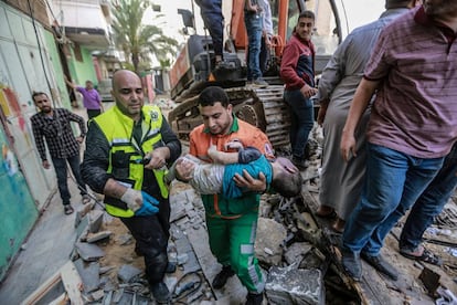 Personal sanitario traslada el cuerpo de un niño rescatado entre los escombros de un edificio en Gaza. Los equipos de rescate gazatíes han buscado cuerpos y supervivientes entre los escombros durante toda la mañana.