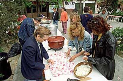 Un grupo de mujeres prepara la mesa para la comida de ayer en Carabanchel.