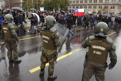 Estudiantes universitarios y de secundaria junto con otros sectores sociales se manifiestan bajo una intensa lluvia frente a las autoridades en el centro de Santiago.