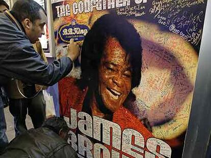 Seguidores de James Brown firman ayer en un cartel que anuncia sus actuaciones en el exterior del local de B. B. King en Nueva York.