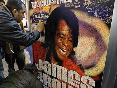 Seguidores de James Brown firman ayer en un cartel que anuncia sus actuaciones en el exterior del local de B. B. King en Nueva York.