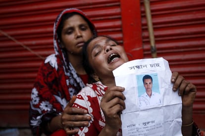 Una mujer muestra un retrato de su hijo desaparecido en el derrumbe de un edificio en Savar, en Dacca (Bangladesh). Las autoridades de Bangladesh pusieron fin a la búsqueda de supervivientes del derrumbe del edificio que el pasado miércoles causó al menos 381 muertos y un número indeterminado de desaparecidos.