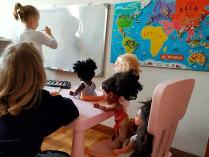 Dos niñas juegan con sus muñecas a que siguen yendo al colegio durante el confinamiento.