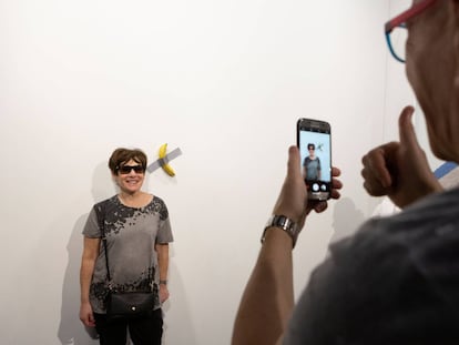 Una mujer se fotografía junto a la obra 'Comedian', el sábado en Miami.