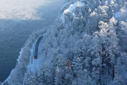 Un tren de pasajeros a su paso por el río Yenisei, el 11 de febrero de 2019, en la Taiga de Siberia.  