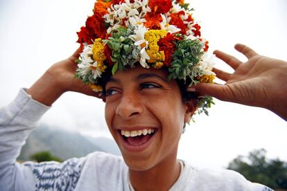 Un chico que vende flores decora su cabeza con algunas de ellas, el 18 de abril de 2017 en Abha (Arabia Saudí).