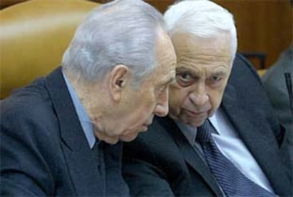 El rimer ministro Israelí, Ariel Sharon (d) habla con el ministro de Asuntos Exteriores Simon Peres (i)