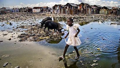 La imagen de una niña haitiana caminando descalza entre charcos de barro y mugre en un barrio de chabolas de Puerto Príncipe, ganadora del premio de fotografía Unicef 2009.