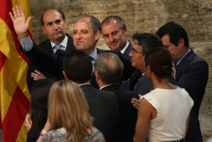 Francisco Camps saluda tras anunciar públicamente su dimisión, acompañado de consejeros de su equipo en la Generalitat valenciana.