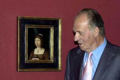 El rey Juan Carlos observa el retrato de la reina Isabel ayer durante la inauguración de la muestra.