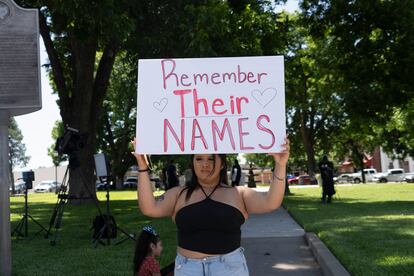 Una joven levanta una pancarta con la frase "recuerden sus nombres", durante una protesta en el centro de Uvalde, el 25 de mayo de 2022. 