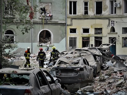 Tres bomberos caminaban este jueves entre los escombros, después de un ataque ruso en la ciudad ucrania de Lviv.