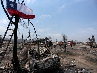 Los habitantes de un campamento irregular en Viña del Mar recogen los escombros tras el incendio, este 4 de febrero.