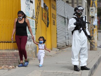 Un soldado con un traje para la covid vigila una calle de Ciudad Bolívar, uno de los barrios más afectados por la pandemia en Bogotá.