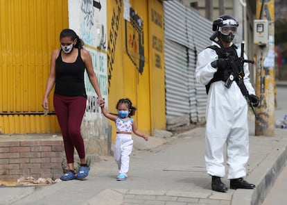 Un soldado con un traje para la covid vigila una calle de Ciudad Bolívar, uno de los barrios más afectados por la pandemia en Bogotá.